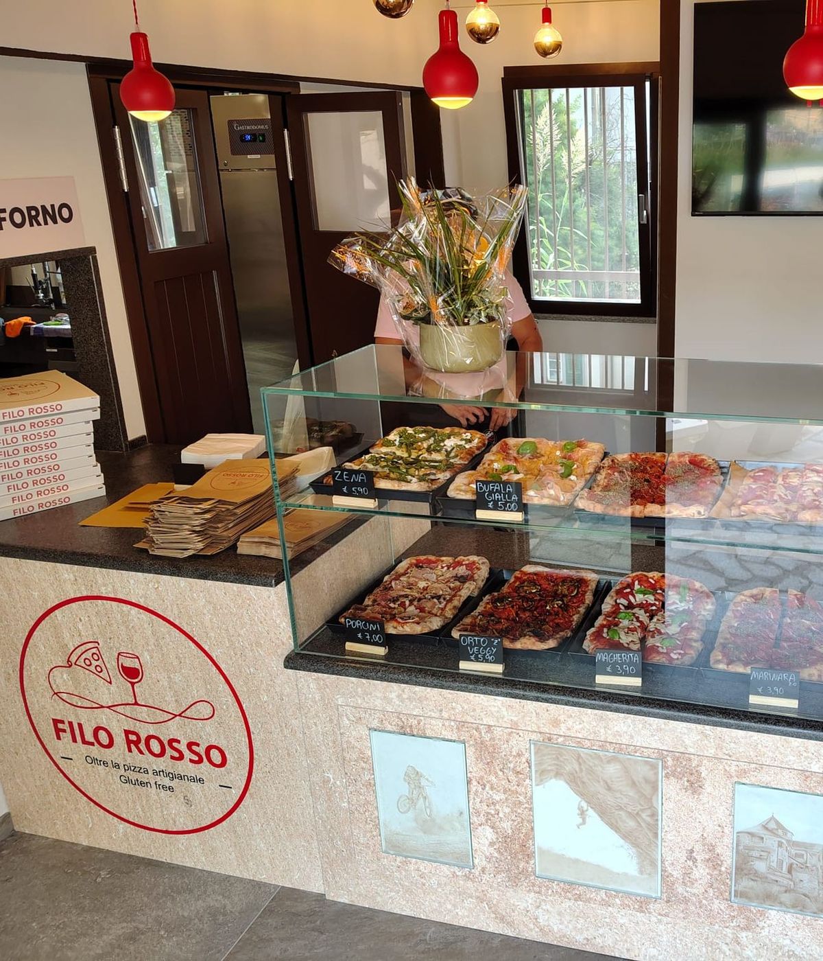 La vetrina del banco di Filo Rosso, con le pizze in teglia e il logo